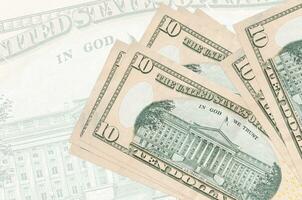 10 billets de dollars américains sont empilés sur fond de gros billets de banque semi-transparents. présentation abstraite de la monnaie nationale photo