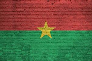 burkina faso drapeau représenté dans peindre couleurs sur vieux brique mur. texturé bannière sur gros brique mur maçonnerie Contexte photo