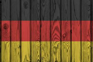 Allemagne drapeau représenté dans brillant peindre couleurs sur vieux en bois mur. texturé bannière sur rugueux Contexte photo