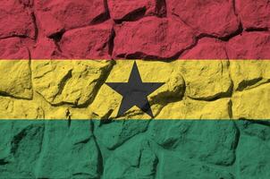 Ghana drapeau représenté dans peindre couleurs sur vieux pierre mur fermer. texturé bannière sur Roche mur Contexte photo