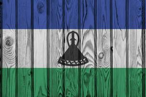Lesotho drapeau représenté dans brillant peindre couleurs sur vieux en bois mur. texturé bannière sur rugueux Contexte photo