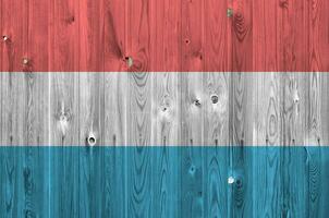 Luxembourg drapeau représenté dans brillant peindre couleurs sur vieux en bois mur. texturé bannière sur rugueux Contexte photo
