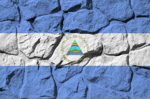 Nicaragua drapeau représenté dans peindre couleurs sur vieux pierre mur fermer. texturé bannière sur Roche mur Contexte photo