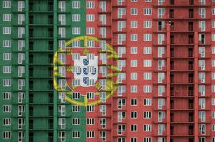 le Portugal drapeau représenté dans peindre couleurs sur à plusieurs étages résidentielle bâtiment en dessous de construction. texturé bannière sur brique mur Contexte photo