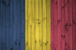 tchad drapeau représenté dans brillant peindre couleurs sur vieux en bois mur. texturé bannière sur rugueux Contexte photo