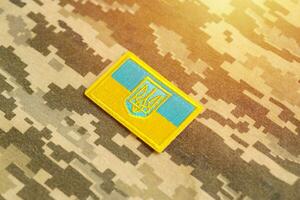 tissu de camouflage militaire avec le drapeau ukrainien sur un chevron d'uniforme photo