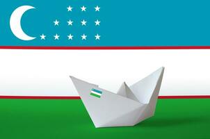 Ouzbékistan drapeau représenté sur papier origami navire fermer. Fait main les arts concept photo