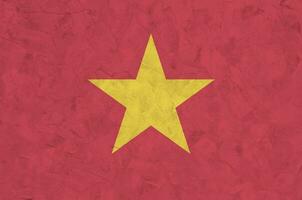 drapeau du vietnam représenté dans des couleurs de peinture vives sur un vieux mur de plâtrage en relief. bannière texturée sur fond rugueux photo