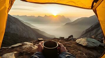 camping en portant une tasse dans un ouvert Jaune tente avec une brumeux Montagne allumé par Naturel lumière. photo