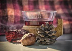 une tasse de vin chaud sur une table avec des fruits d'automne autour photo