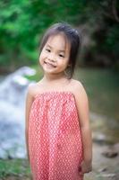 portrait de petite fille asiatique se prépare à jouer dans l'eau de la nature en vacances photo