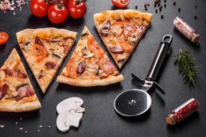 délicieuse pizza fraîche faite dans un four à sole avec des tomates, des saucisses et des champignons photo