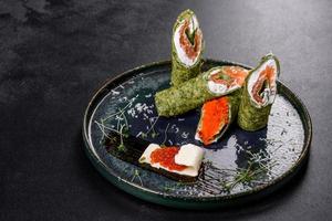 De délicieuses crêpes sucrées fraîches sur une assiette avec du poisson rouge et du caviar photo