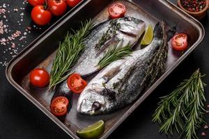 poisson dorado cru aux épices cuisant sur une planche à découper. daurade de poisson frais photo