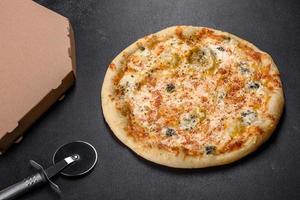 savoureuse pizza au four frais avec tomates, fromage et champignons sur fond de béton foncé photo