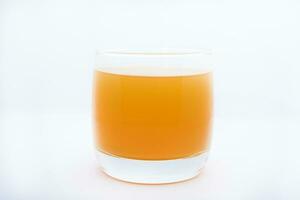 verre des lunettes avec Orange jus sur une blanc Contexte. délicieux Orange refroidissement boire. photo