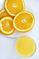 Orange jus dans une verre verre et le fruit de des oranges. rafraîchissant boisson sur une blanc Contexte de fruit. photo