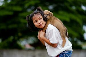 Jeune fille pièces avec une peu chiot Heureusement inter-espèces l'amour l'amour de gens et animaux domestiques photo