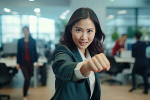 asiatique femme d'affaires montrant une combat pose, magnifique directeur gestes élevage les poings dans moderne bureau, femelle entrepreneur combats une problème, célébrer Succès et réalisation buts photo