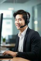 portrait de une Beau asiatique homme, client un service opérateur, appel centre ouvrier parlant par casque avec client dans moderne bureau. photo