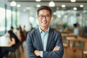 portrait de une Beau homme d'affaire dans moderne bureau, asiatique directeur à la recherche à caméra et souriant, sur de soi Masculin PDG Planification et gérant entreprise stratégie. photo