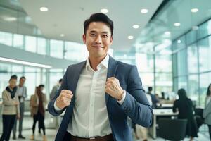 asiatique homme d'affaire montrant une combat pose, Masculin entrepreneur gestes élevage les poings dans moderne bureau, combats une problème, célébrer Succès et réalisation buts. photo