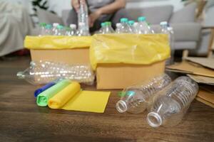 Accueil recycler éco vert zéro concept homme lancement vide Plastique bouteille dans recyclage poubelle avec Jaune des ordures Sacs à Accueil photo