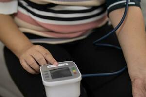 femme en surpoids plus Taille soi chèques mesure du sang pression et cœur taux tonomètre soi vérification à Accueil photo