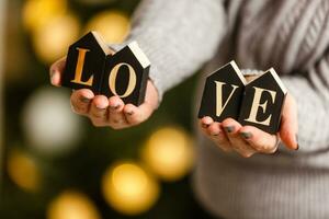 femme détient des lettres l'amour près Noël arbre avec jouets photo