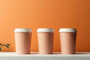 Trois identique papier carton tasses avec blanc casquettes pour café à aller sur une table sur une beige Contexte photo