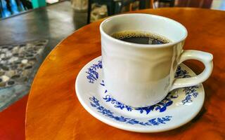 pot de tasse blanc bleu avec table basse en bois noir mexique. photo