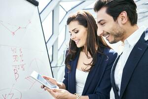 homme d'affaire et femme d'affaires travail avec tablette et retourner graphique dans Bureau photo