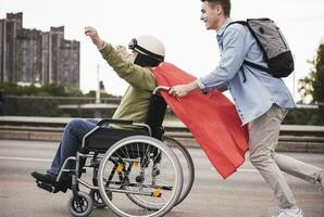 Jeune homme pousser Sénior homme séance dans une fauteuil roulant habillé en haut comme super-héros photo