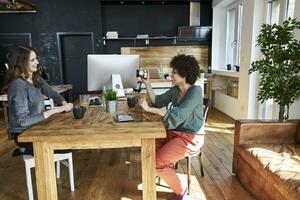 deux content Jeune femmes avec caméra dans moderne Bureau photo