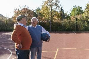 deux en forme les personnes âgées ayant amusement sur une basketball champ photo