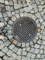 couvercle de trou d'homme du système de gazoduc. une trappe métallique massive pour l'accès aux communications de la ville dans le trottoir. photo