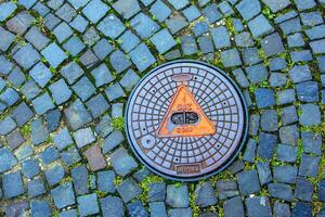 couvercle de trou d'homme du système de gazoduc. une trappe métallique massive pour l'accès aux communications de la ville dans le trottoir. photo