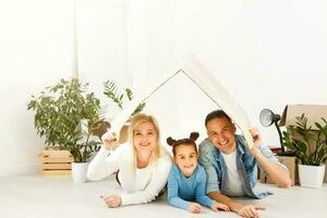 content famille avec papier carton des boites dans Nouveau maison à en mouvement journée. photo