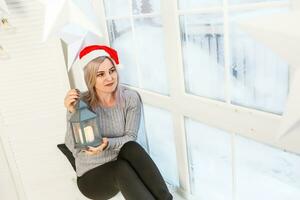 femme près Noël arbre avec Noël lanterne photo