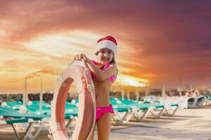 jolie femme profiter sa Noël les vacances près le bassin. photo