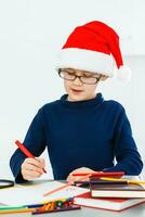 une peu garçon l'écriture une lettre à Père Noël photo