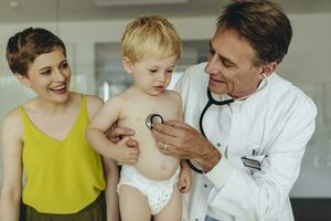 pédiatre examiner bambin avec stéthoscope, mère permanent suivant à leur photo