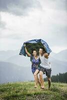 content couple fonctionnement sur une Prairie dans le montagnes dans pluie, achenkirch, L'Autriche photo