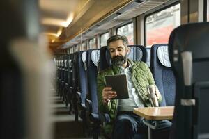 homme séance dans train en utilisant tablette photo