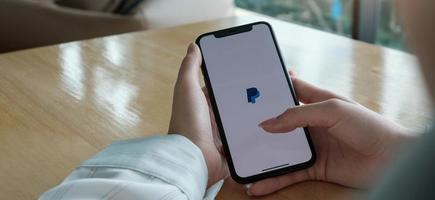 femme tenant l'iphone xs avec l'application paypal sur l'écran photo