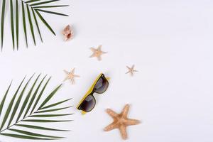 accessoires de plage, lunettes et chapeau avec coquillages et étoiles de mer sur fond coloré photo