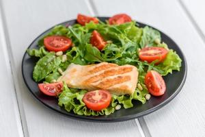 délicieuse salade fraîche avec du poisson, des tomates et des feuilles de laitue