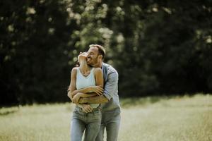 jeune couple affectueux s'amusant sur l'herbe verte photo