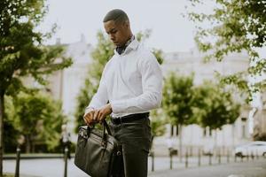 jeune homme d'affaires afro-américain en attente d'un taxi dans une rue