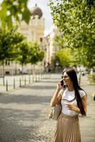 jeune femme à l'aide d'un téléphone portable en marchant dans la rue photo